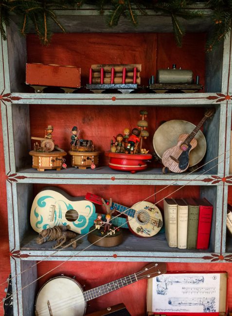 libreria dipinta Settecento tosco-marchigiana con ukulele e banjolele vintage, libri rari da collezione manuali Hoepli, carillon vintage in legno Anri, trenino giocattolo in legno vintage
